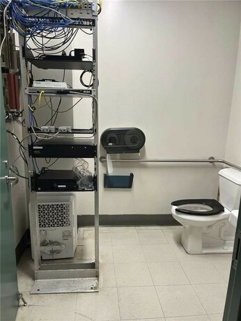 Photo of an active server rack in a restroom within reach of a toilet... For when your network engineers have shit to do.